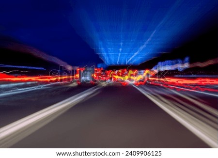View through a cars windshield on a german autobahn motorway at night. Blurred lights and linear light traces from moving lights, signs and roadmarking caused by the motion, speed and zoom effect.