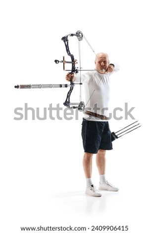 Full-length of serious man, archery sportsman aiming archery bow on target isolated over white studio background. Concept of professional sport and hobby, competition, action, game