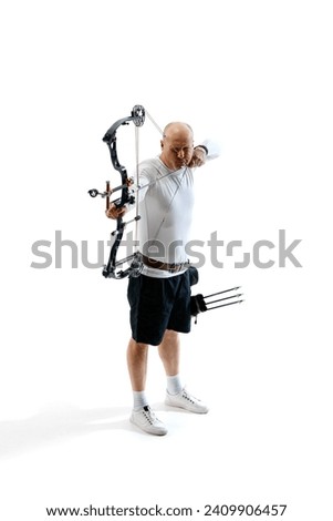 Man, professional archer training, aiming archery bow into target isolated over white studio background. Concept of professional sport and hobby, competition, action, game