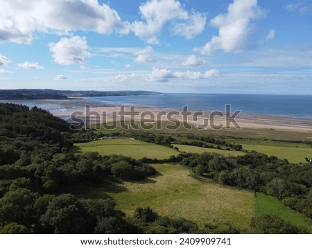 Aerial photograph over the breathtaking fields by Red Wharf Bay in Anglesey, Wales, UK with village of Benllech in background Royalty-Free Stock Photo #2409909741