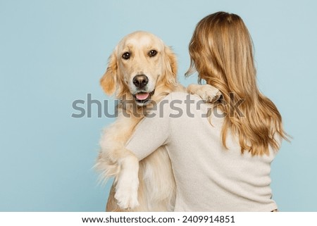 Back rear view young owner blonde woman with her best friend retriever dog she wear casual clothes hug embrace dog isolated on plain pastel light blue background studio. Take care about pet concept Royalty-Free Stock Photo #2409914851