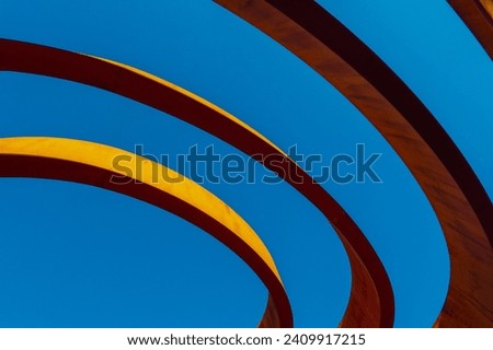 Abstract view of a modern sculptural architecture with vibrant red and yellow curves. Royalty-Free Stock Photo #2409917215