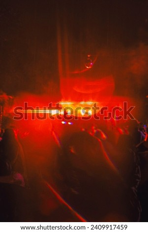 Low shutter speed intensifies dynamic red lights, embodying the lively energy of a pulsating club atmosphere. Ideal for adding excitement to projects