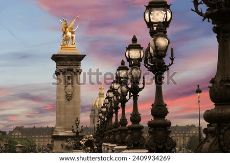 Lamp posts on Alexander III Bridge against the background of a beautiful sky at sunset. Paris, France. This arch bridge is one of the most beautiful river crossings in the world