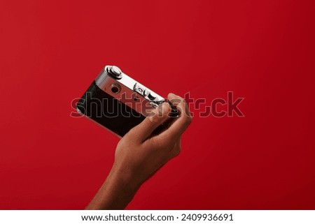 cropped photo of african american photographer taking shot on retro camera on red background