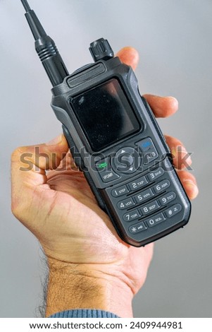 amateur radio walkie talkie portable triband held in the hand of a white man Royalty-Free Stock Photo #2409944981