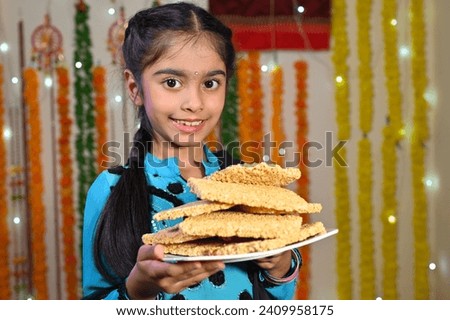 cute girl celebrating Lohri with dance and gajak.