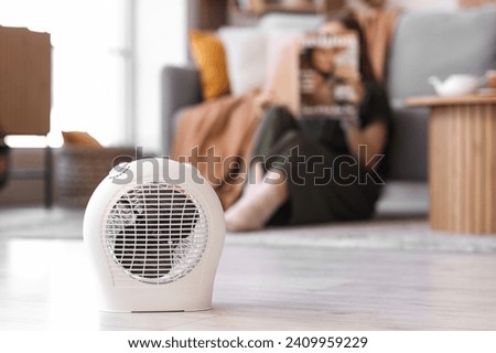 Electric fan heater on floor in living room Royalty-Free Stock Photo #2409959229
