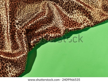 Satin fabric, animal print on bright green background, fashionable print combo, creative copy space.