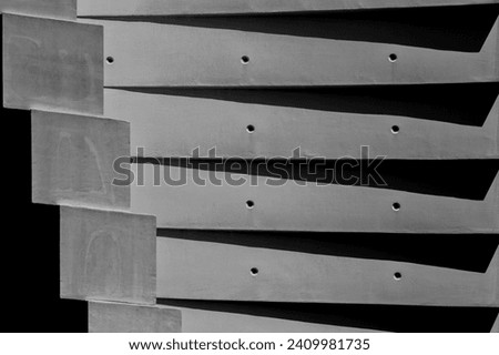 Abstract architectural background in black and white. Detail of contemporary concrete building with step shapes. Wall in shades of gray. Forms in gray shades. Strong, hard, solid, powerfull concept Royalty-Free Stock Photo #2409981735