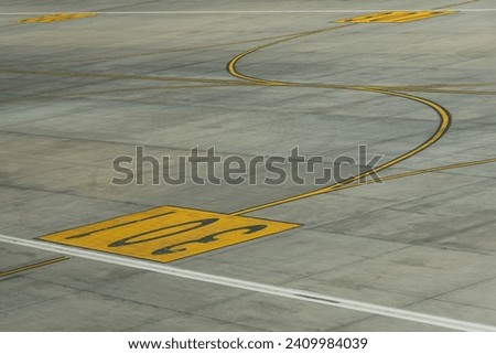 Yellow lines markings for aircraft movement with parking numbers on the apron at the airport