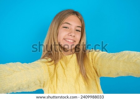 Photo of Caucasian teenager girl wearing yellow knitted sweater do selfie