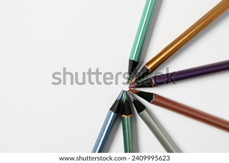 Composition with different color pencils on white background, closeup