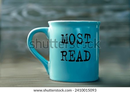 MOST READ - words on a blue cup on a dark background. Info concept Royalty-Free Stock Photo #2410015093