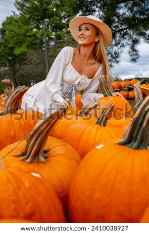 A beautiful European blonde female pics out some pumpkins and flowers for the upcoming fall festivals