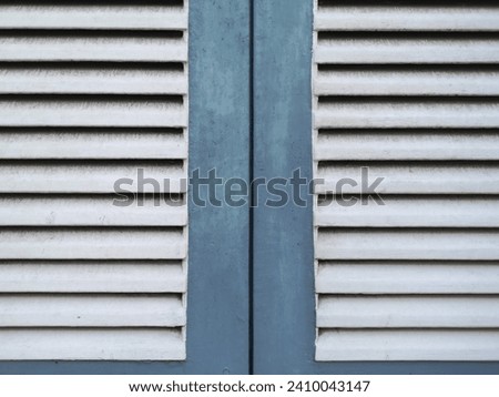 Close-up photo of white and blue old closed wooden windows covered with dust