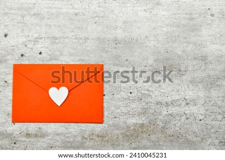 Captivating Love Letter: A Closed Red Envelope on a Subtle Grey Background, Featuring a Central White Heart