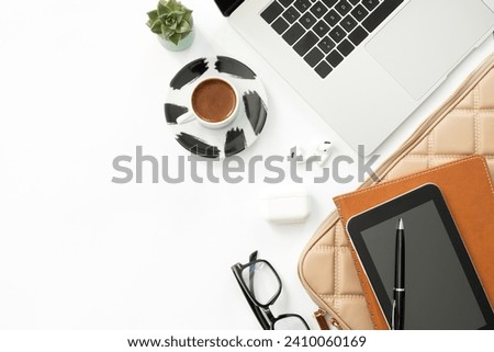Women's bag with office accessories on a white background, top view. Copy space