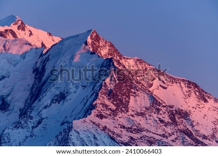 The pink colored Aiguille de Bionnassay in Europe, France, Rhone Alpes, Savoie, Alps, in winter on a sunny day.