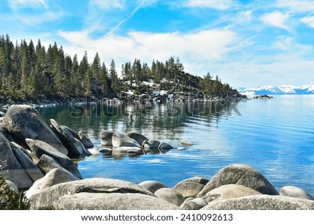 Lake Tahoe calm water and snow covered mountains in background