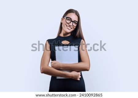 Young business woman with clipboard looking at camera on white background Royalty-Free Stock Photo #2410092865