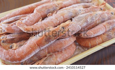 Frozen red shrimp on a tray.