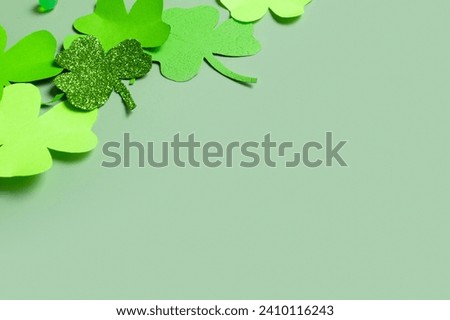 St. Patrick's Day minimalistic concept. Paper clover leaves on colored background with copy space.