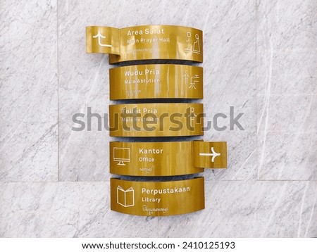 Copper direction signs on marble walls at the Sheikh Zayed mosque, Surakarta Royalty-Free Stock Photo #2410125193