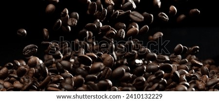 Coffee roasted bean fly explosion, Coffee crushed float pouring mix with beans. Roasted Coffee bean splash explosion in mid Air. Black background Isolated selective focus blur