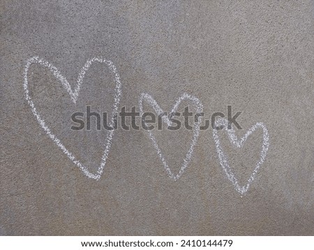 drawing three white hearts on gray cement wall texture. convey love and express love, with the concept of loving.