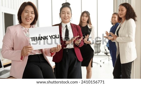Group of businesspeople join together greeting and hold thank you word for sign of thankfulness to someone in modern office. Idea for good teamwork feeling declaration and support for colleagues.