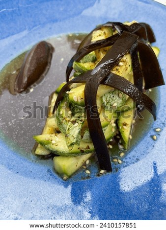 A dish of pickled zucchini and mushrooms: a tangy mix of cooked squash and mushrooms in vinegar, offering earthy and tangy flavors that complement various dishes. Royalty-Free Stock Photo #2410157851