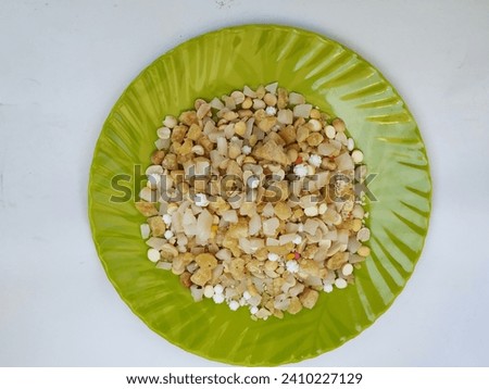 Pile and Heap of a Pongal Traditional Raw Mixtures of Ellu Bella in a Green Plate isolated on white Background Royalty-Free Stock Photo #2410227129