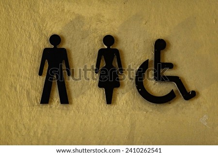 A toilet sign in Bad Radkersburg Austria. It's a public toilete or wc for everyone. The sign stands out on the bright background wall