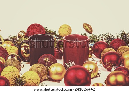 Christmas or New Year decoration with pine or fir and many yellow and red ornaments balls and two cups for couple isolated on white background. Vintage retro photo