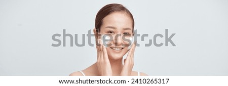 Satisfied girl with bare shoulders applying cleansing beauty product on cheeks. Banner