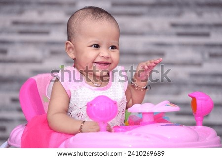 Happy baby girl playing with toy car