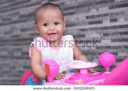 Happy baby girl playing with toy car