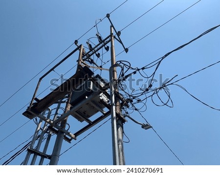 Electrical substation with lots of messy cables around it. Another name is gardu listrik (Indonesian ), kracht huis (Dutch), centrale électrique (French).  Royalty-Free Stock Photo #2410270691