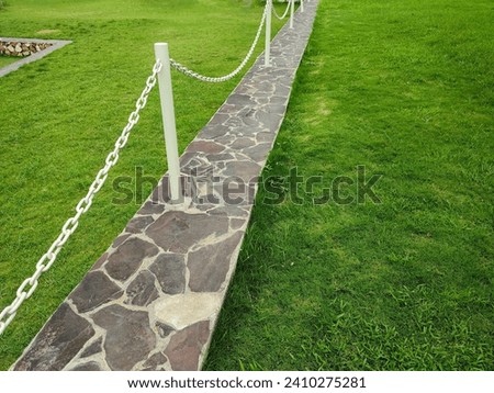 Yard with wide green grass and artistic concrete rock borders