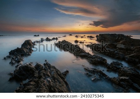 Dreamy Waves. view of rocky beach during sunrise. long exposure photography.
