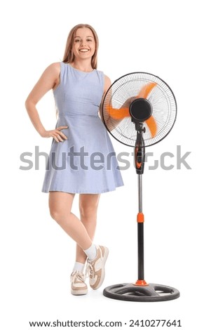 Young woman with electric fan on white background