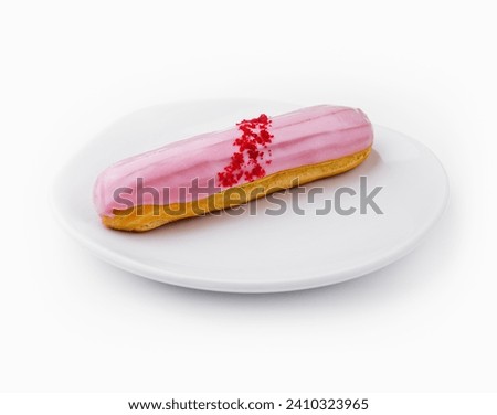 Eclairs with pink glaze on a white plate Royalty-Free Stock Photo #2410323965