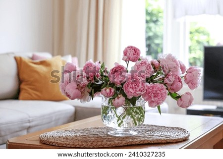 Beautiful pink peonies in vase on table at home, space for text. Interior design Royalty-Free Stock Photo #2410327235