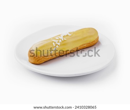 Delicious eclair with custard on plate top view Royalty-Free Stock Photo #2410328065