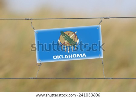 Border fence - Old plastic sign with a flag - Oklahoma