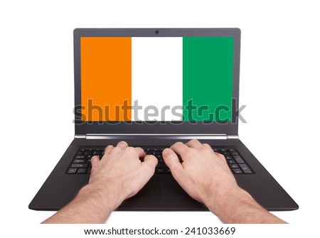Hands working on laptop showing on the screen the flag of Ireland