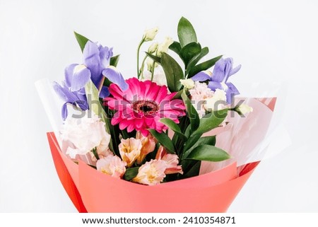 A beautiful bouquet of flowers. Flowers in a package, light background.
