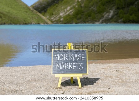 Mortgage markets symbol. Concept words Mortgage markets on beautiful black chalk blackboard. Beautiful sand beach mountain lake background. Business mortgage markets concept. Copy space.