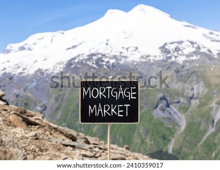 Mortgage market symbol. Concept words Mortgage market on beautiful black chalk blackboard. Beautiful mountain Elbrus blue sky background. Business mortgage market concept. Copy space.